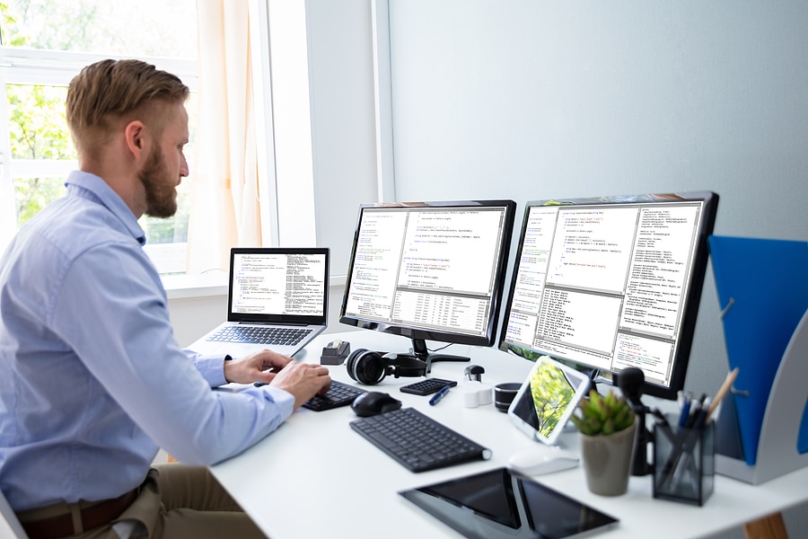 developer workspace single laptop multiple monitors clean desk